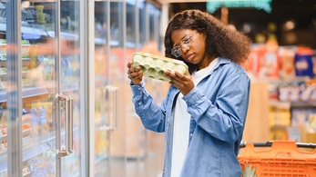 woman looking at egg carton