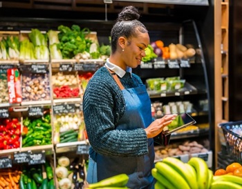 female grocery store worker in fresh aisle