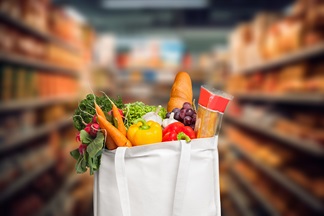 White bag of groceries in a blurred aisle