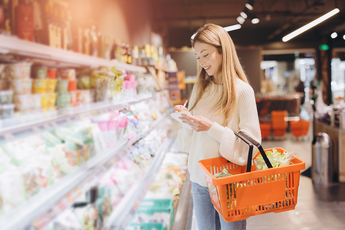 woman grocery shopping with list and basket