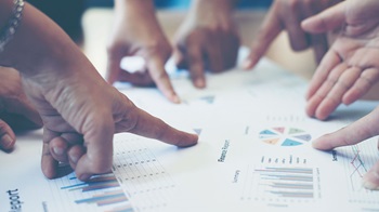 Fingers pointing on reports.