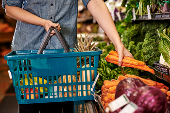 Shopper putting carrots in a basket