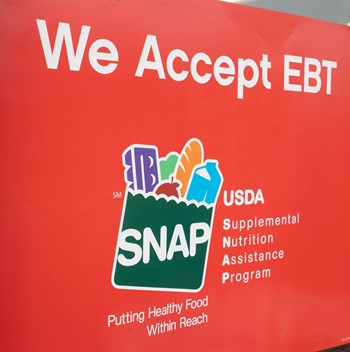 Red sign with SNAP logo that says We Accept EBT