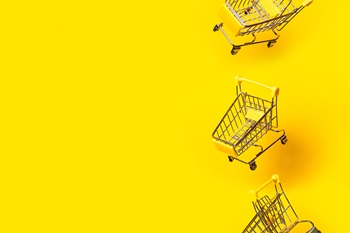 Bright yellow background with three small grocery carts going vertically down one side of the space. 
