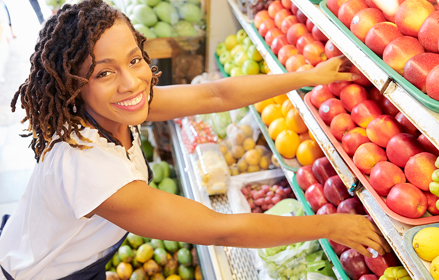 Woman working in grocery store aisle.
