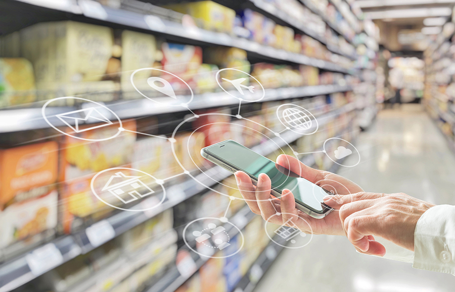 Smartphone in a grocery aisle with icons that indicate omnichannel.
